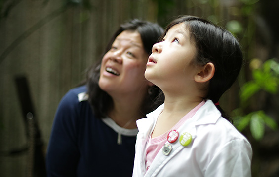 Une mère et sa fille admirent la forêt tropicale du Centre des sciences.