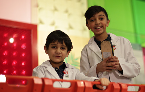 Deux garçons en sarrau dans un module du Centre des sciences.