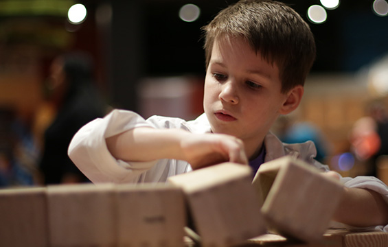 Un petit garçon jouant avec des blocs de bois au Centre des sciences.
