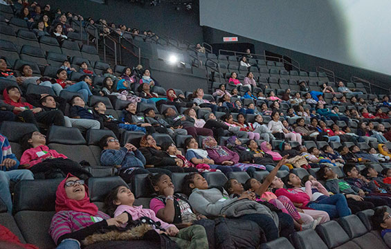 Un auditoire regardant un film du cinéma OMNIMAX au Centre des sciences de l'Ontario.