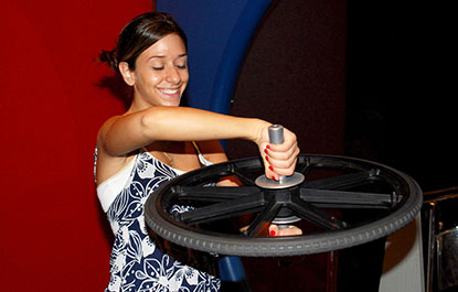 Une femme fait l'expérience de la quantité de mouvement dans l'Arcade des sciences.
