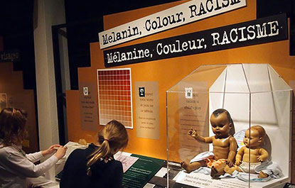 Deux adolescentes se renseignent sur le racisme dans l'exposition La Vérité en question.