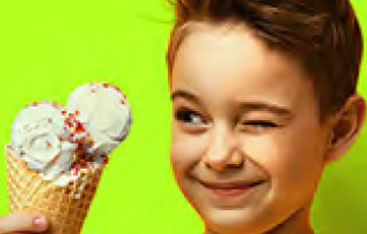 Un garçon regarde un cornet de crème glacée.