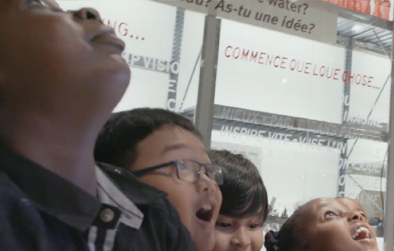 Des enfants s'émerveillent en regardant vers le haut le Centre des sciences de l'Ontario.