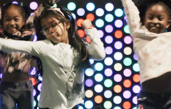 Trois filles dansent au Centre des sciences lors d'une nocturne.