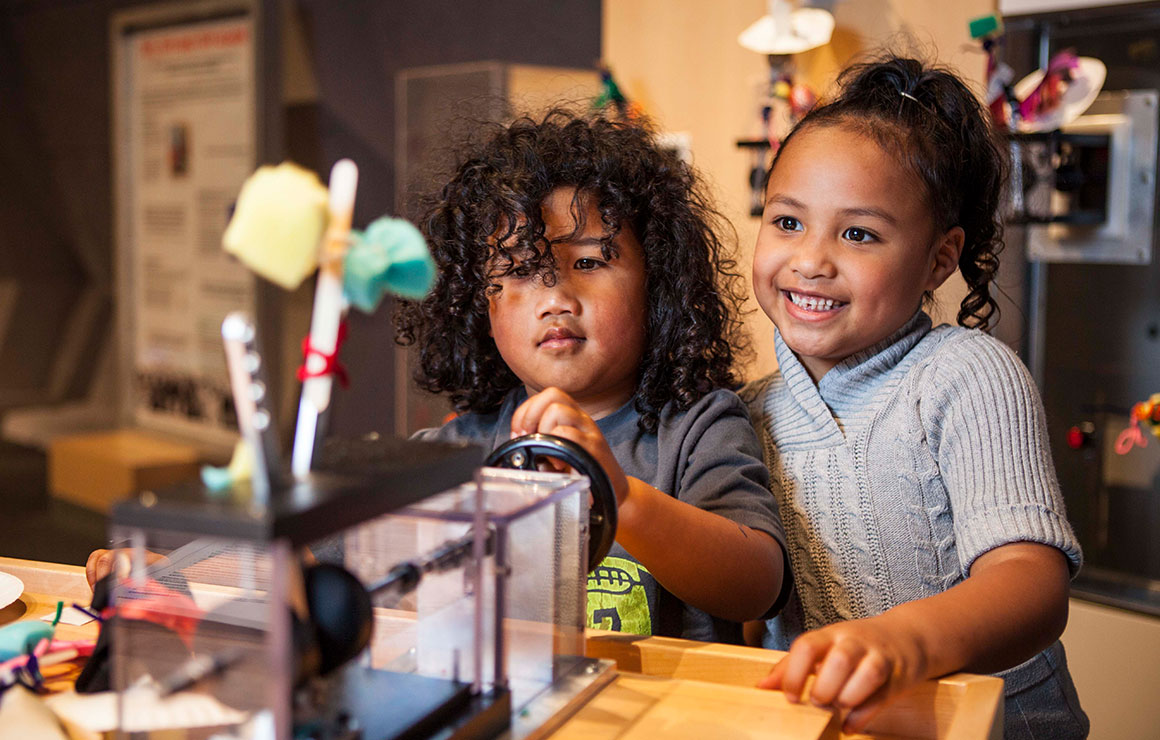 Deux enfants essayent un prototype de module d'exposition.