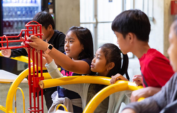 Des enfants jouant avec une sculpture cinétique.