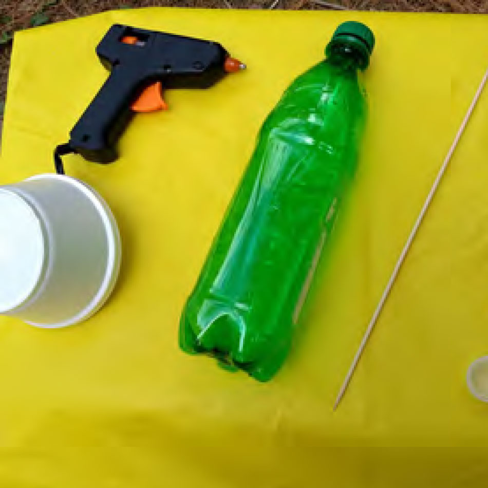 Une partie du matériel nécessaire à l'activité, soit une bouteille en plastique et un pistolet à colle chaude.