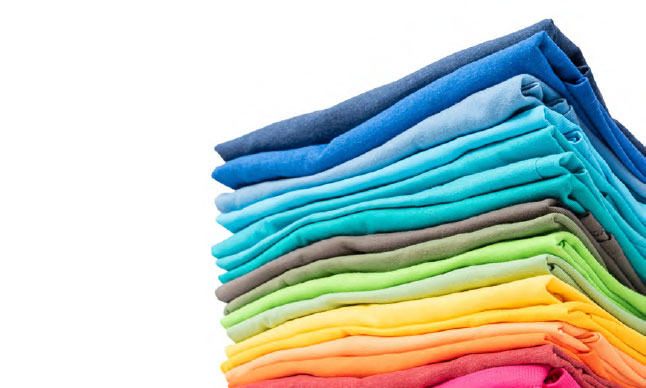 Une pile de vêtements pliés suivant les couleurs de l'arc-en-ciel.