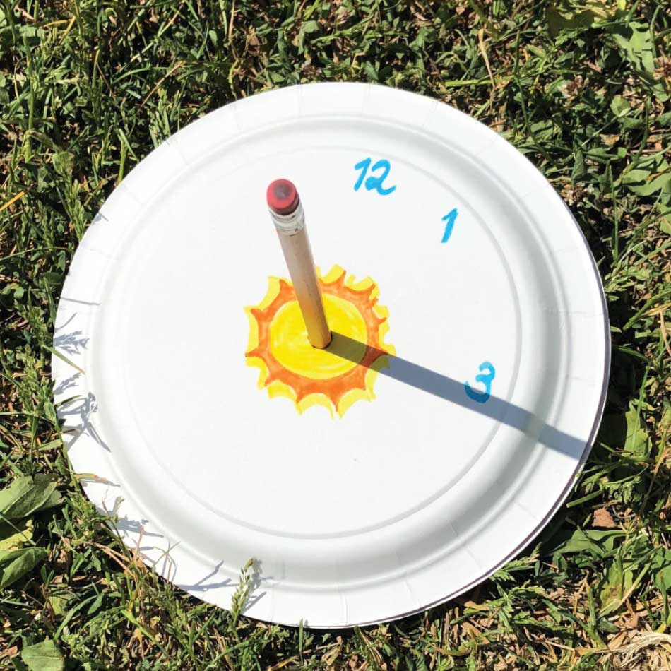 Une assiette aux numéros «12», «1» et «3» a un crayon planté au milieu tandis que l'ombre du crayon passe sur le numéro 3, comme l'aiguille d'une horloge.
