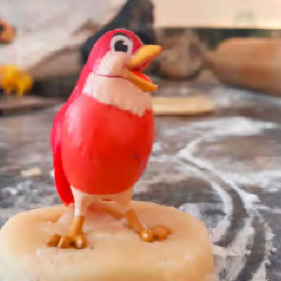 Un oiseau jouet enfoncé dans de la pâte à biscuit.
