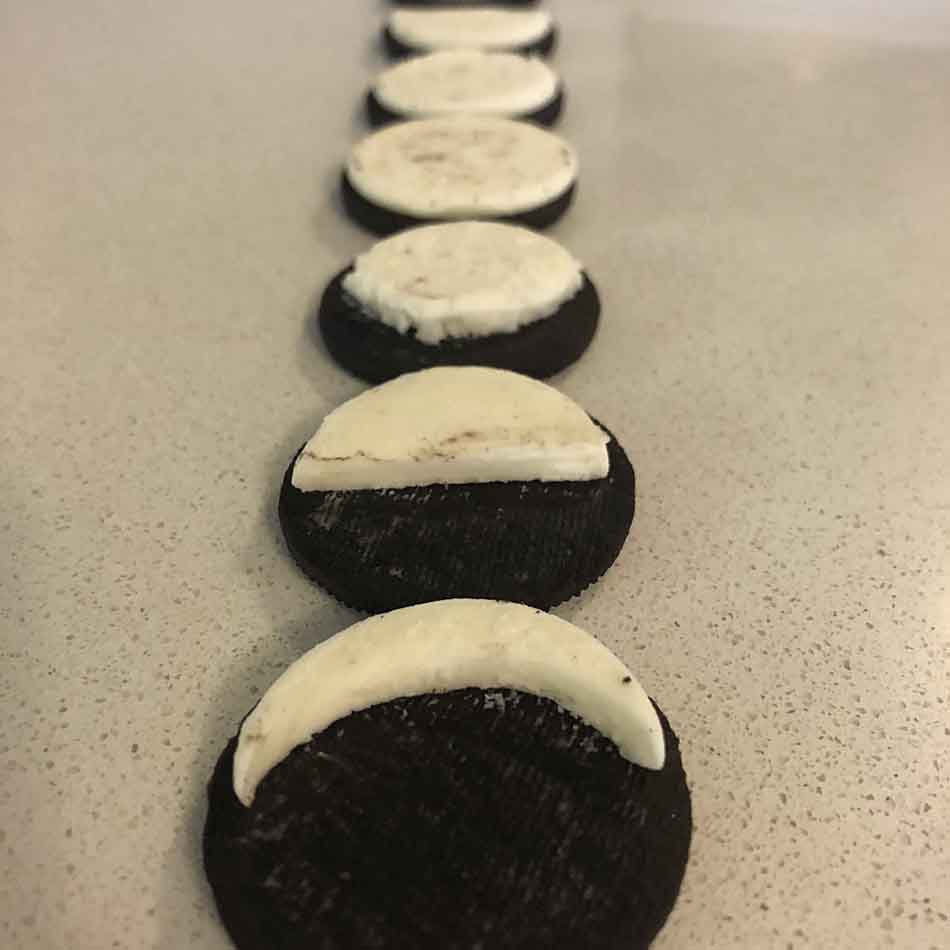 Biscuits alignés dont le crémage est modelé différemment de façon à ressembler aux phases de la Lune.