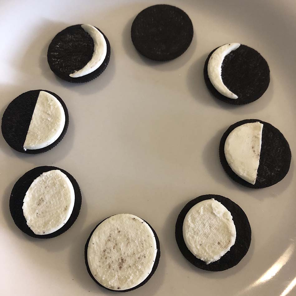 Biscuits disposés en rond sur une assiette, leur crémage modelé de façon à imiter les phases de la Lune.