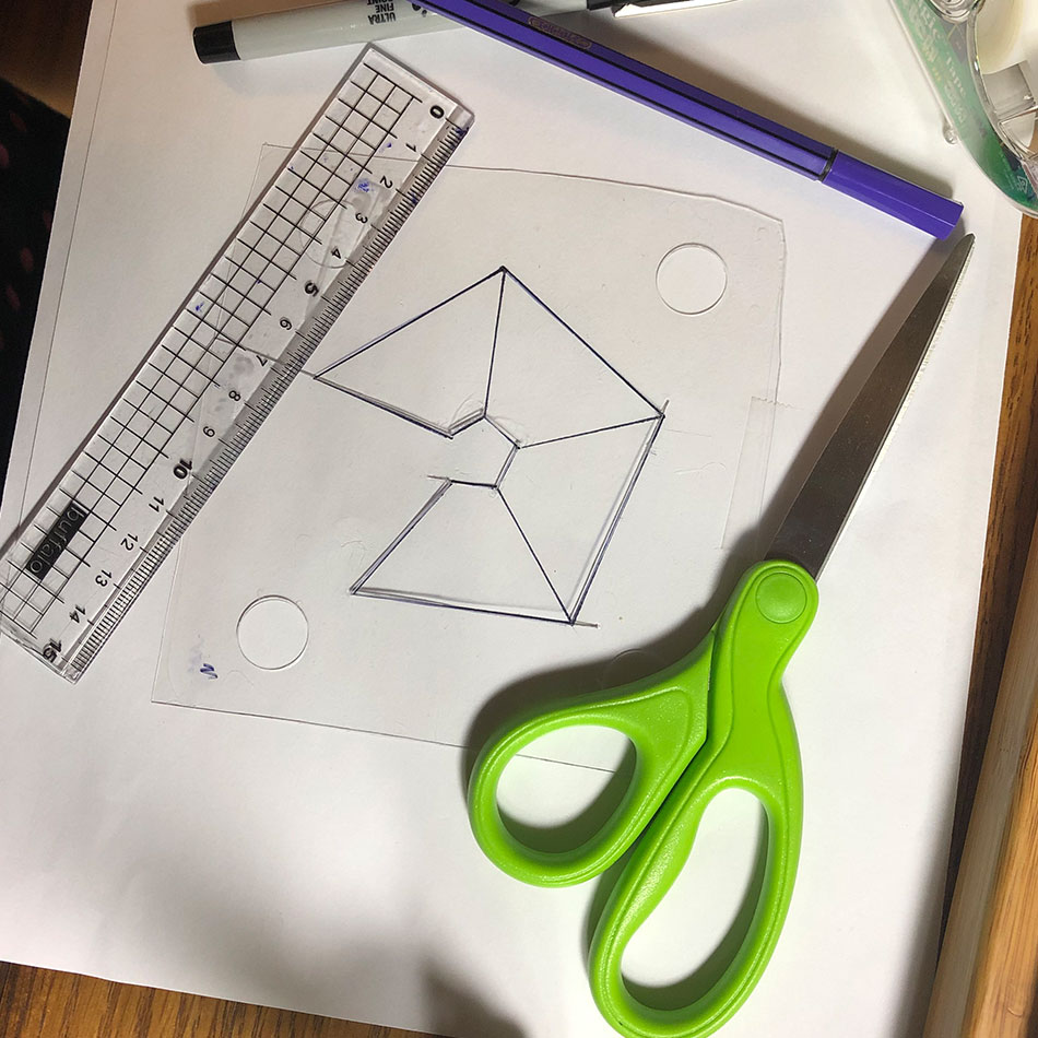 Divers outils du projet, dont des ciseaux, une règle et une feuille de plastique.