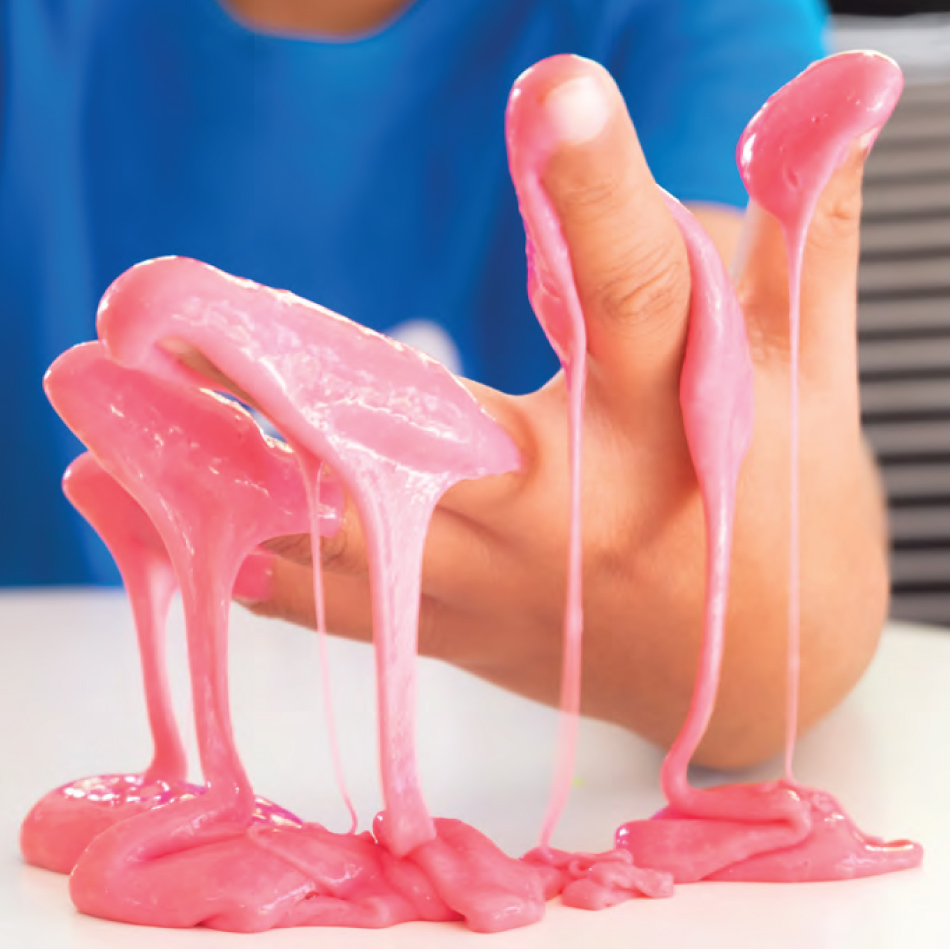 Gros plan d'une main d'enfant dégoulinante de glu rose.