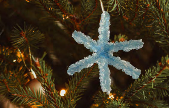 Un flocon de cristal décore un arbre de Noël.