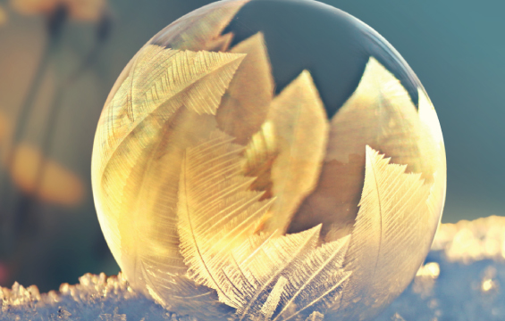 A frozen ice orb sits outside in the snow.