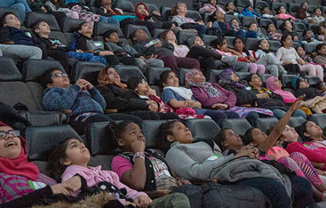 People seated in the OMNIMAX theatre.