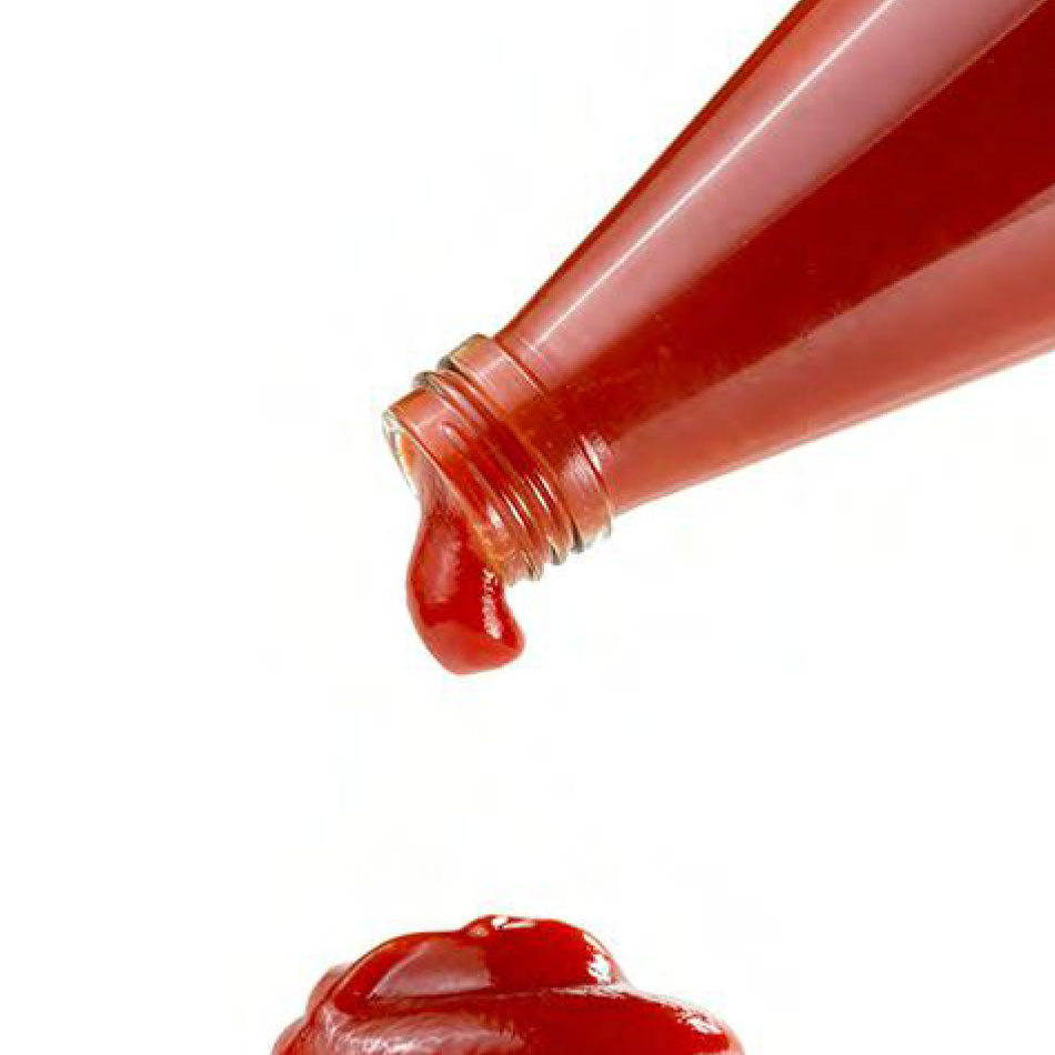Du ketchup dégouttant d'une bouteille.