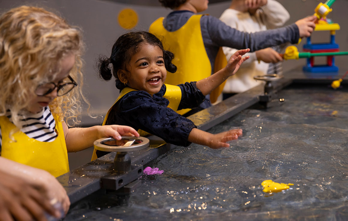 Des enfants jouent à une table d'eau.