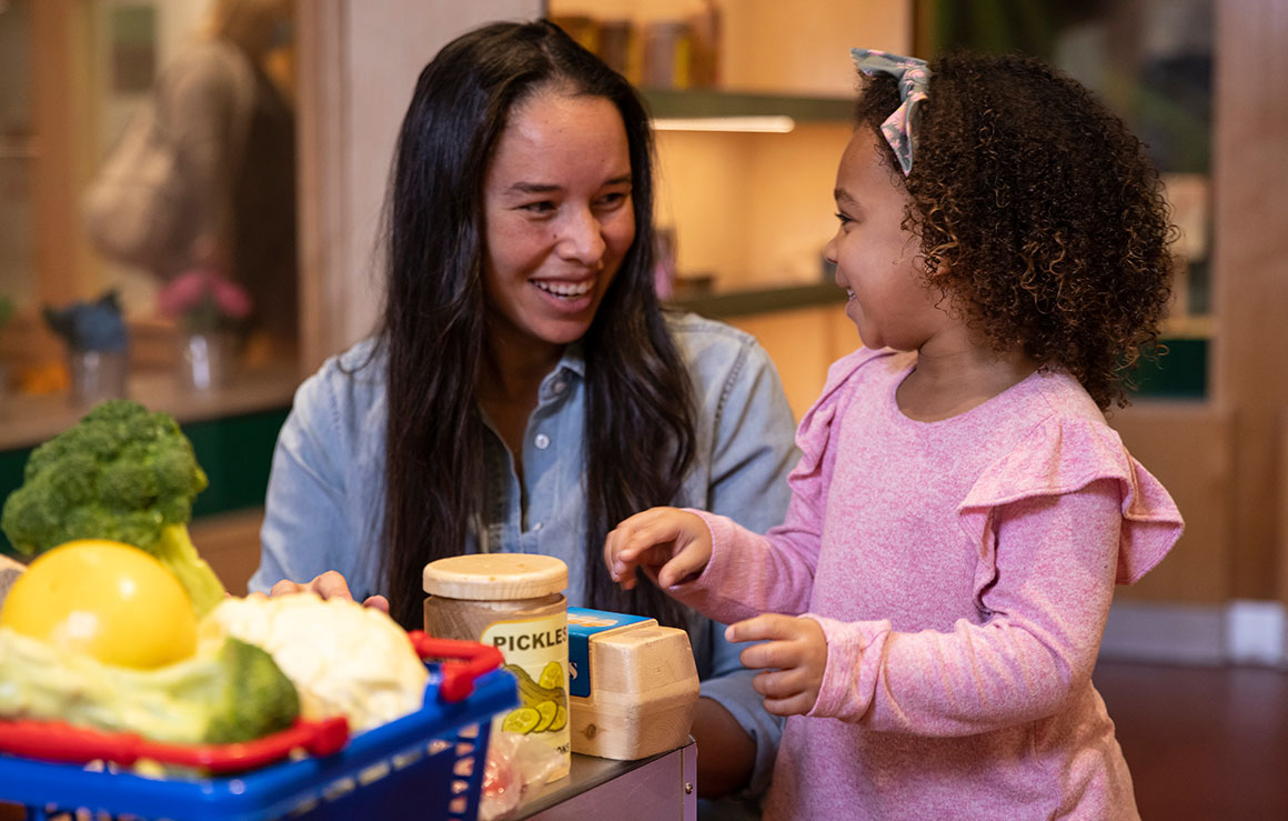 Une femme et une fille s'amusent avec des aliments jouet.