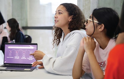 Deux élèves présentent leur projet sur un portable.