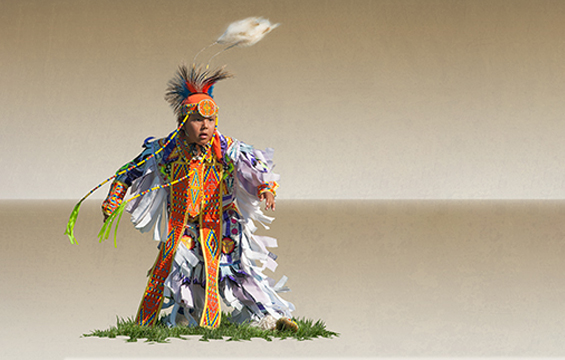 [Un garçon vêtu d'une tenue traditionnelle autochtone complète.