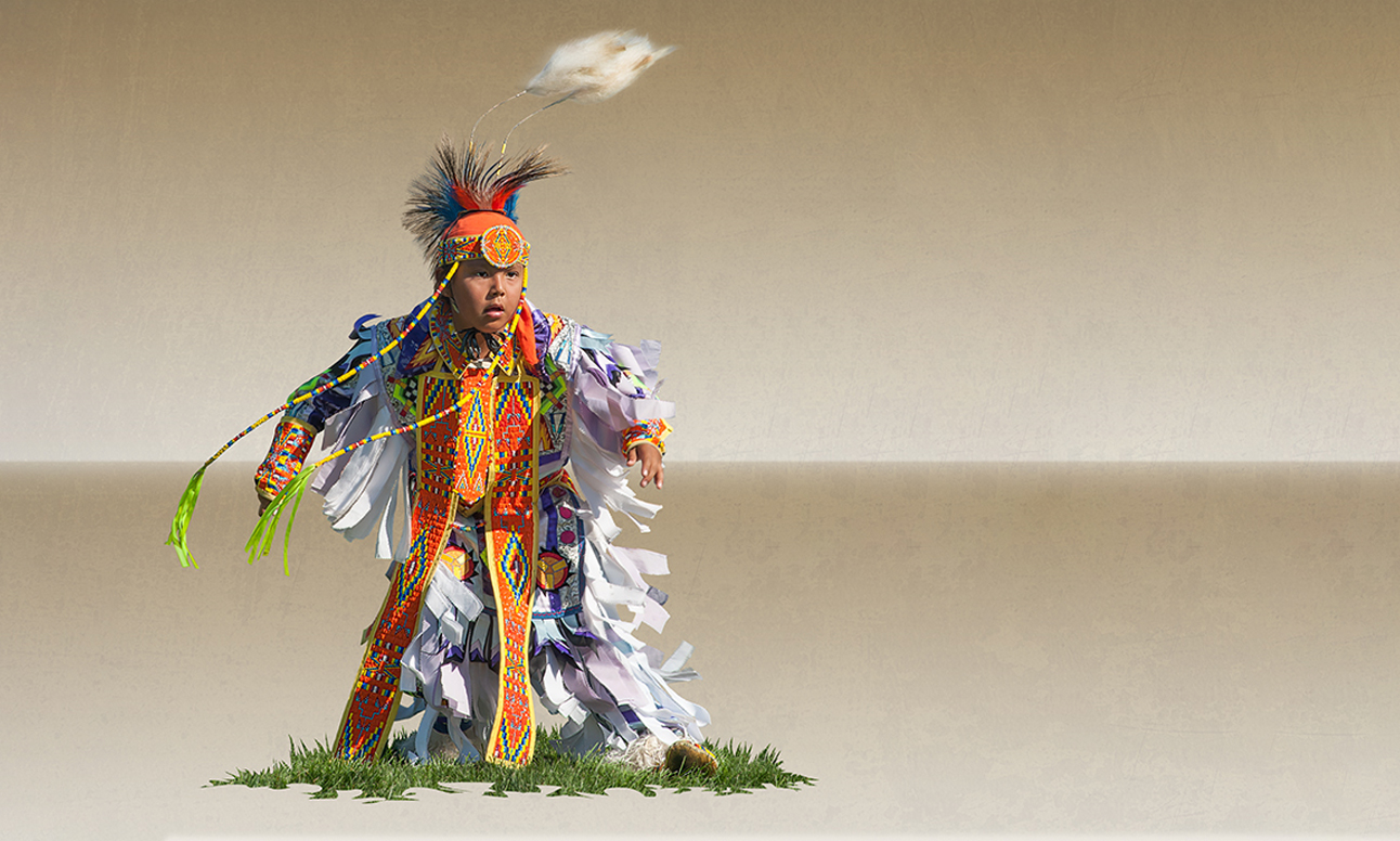 [Un garçon vêtu d'une tenue traditionnelle autochtone complète.