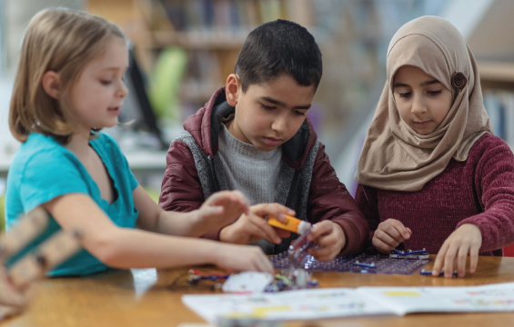 Trois enfants collaborant à un projet.