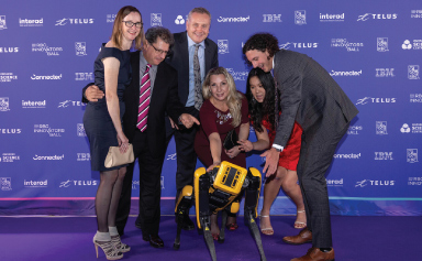 Un groupe de convives du gala posent avec un robot.