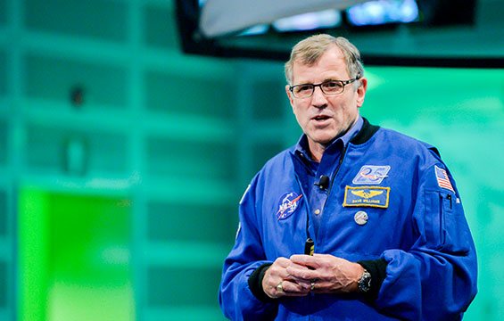 Le Dr Dave Williams en uniforme d'astronaute, prenant la parole au Centre des sciences.