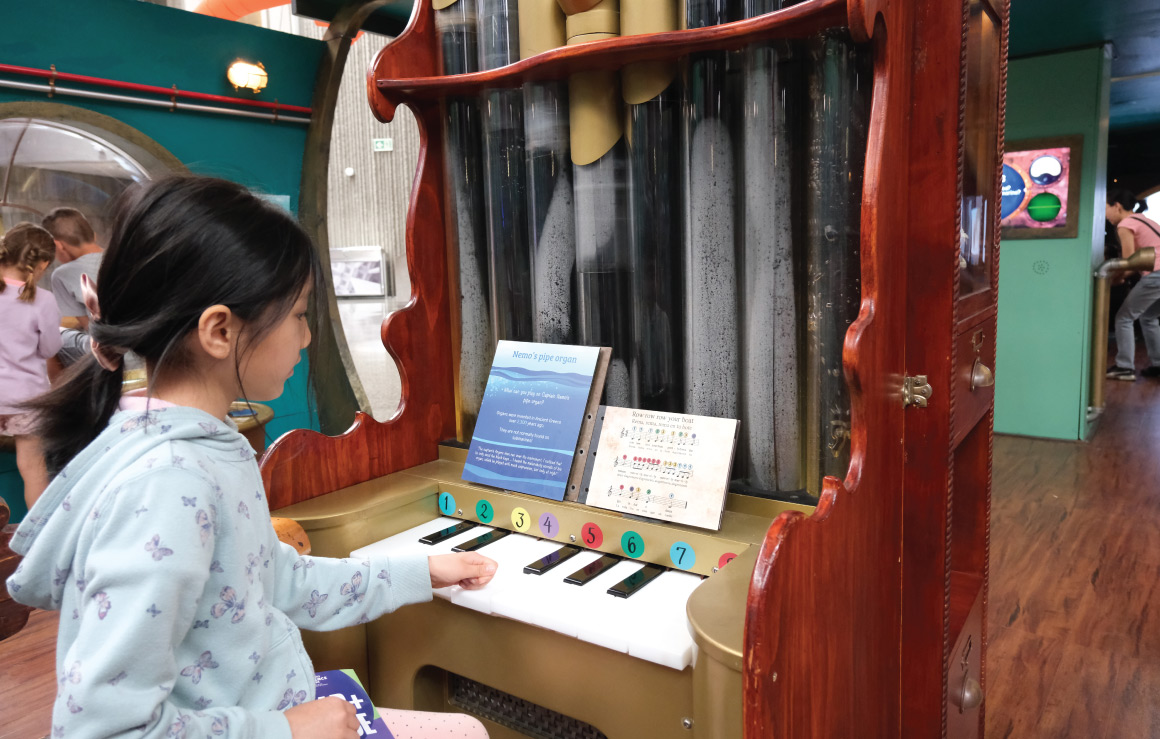 Une enfant joue de l'orgue dans l'exposition.