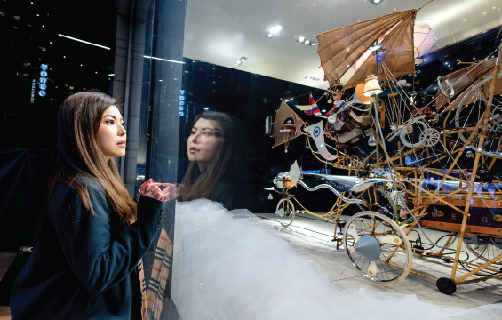 Une femme regarde une Machine de rêve dans une vitrine.
