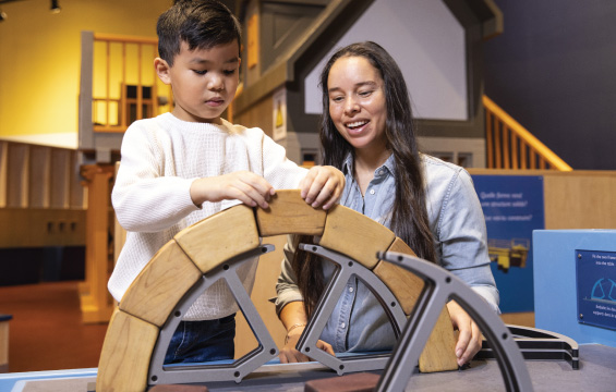 Un élève et son enseignante construisent une arche avec des blocs de bois.