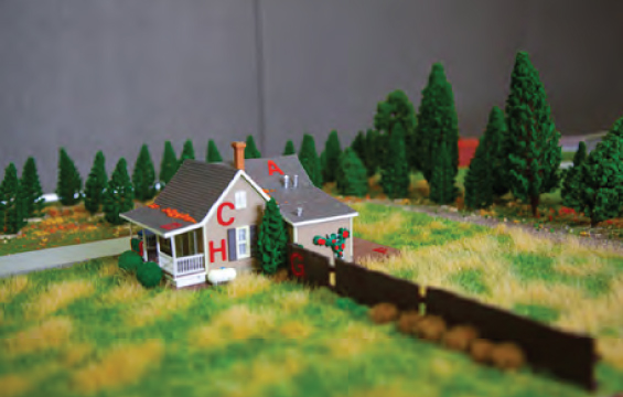 Un diorama d'une maison exposée à un risque de feu de forêt incontrôlé.