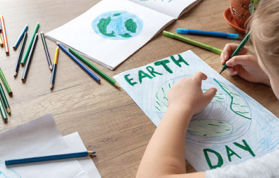 Des mains de petit enfant dessinent sur le thème de «Earth Day» (Jour de la Terre).