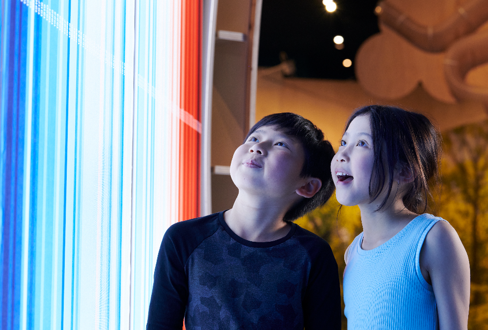 Two children marvel in front of an exhibition module.