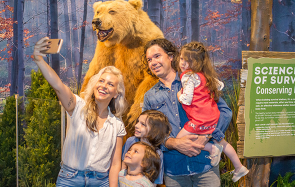Une famille prend un selfie avec un ours.