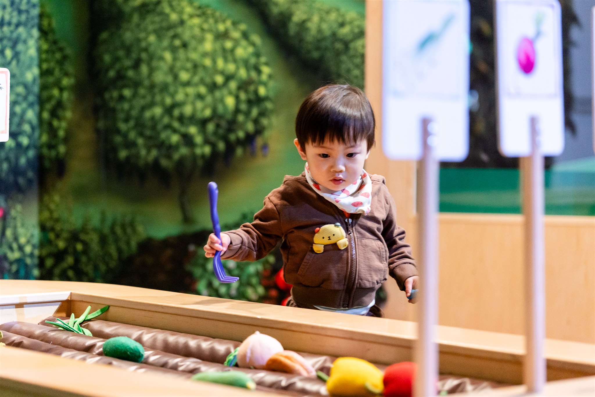 [A boy in the dirt free garden inside KidSpark.][Un garçon dans le jardin sans terre de KidSpark.]