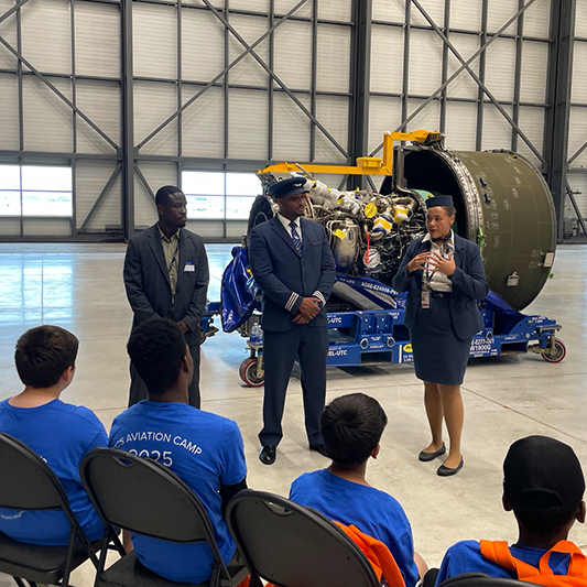 Trois pilotes se présentent à un groupe d'enfants.