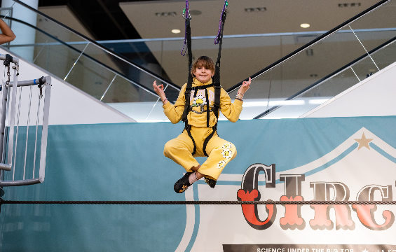 Une fille fait une pose de yoga sur la corde raide de l'exposition «Le Cirque!» à CF Sherway Gardens.