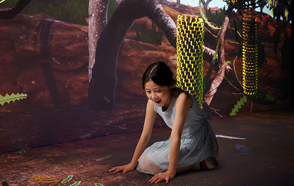 Une fille joue dans l'espace d'exposition Terre entière.