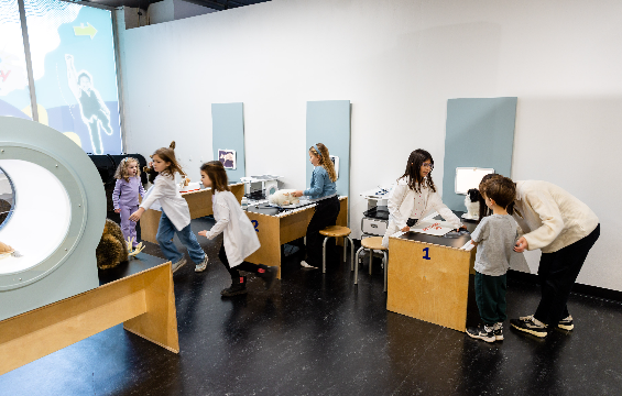 Un groupe d'enfants joue avec des jouets à la table du médecin, au centre de santé.