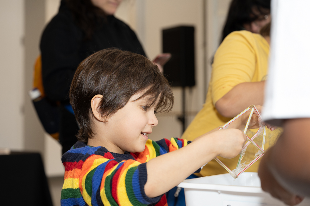 Un enfant dans un chandail arc-en-ciel effectue une expérience scientifique.