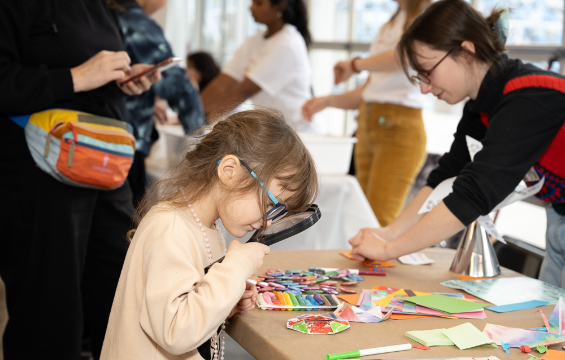 Une fille regardant à travers une loupe.