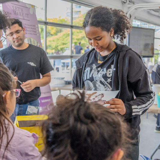 Une jeune femme regarde un poster.