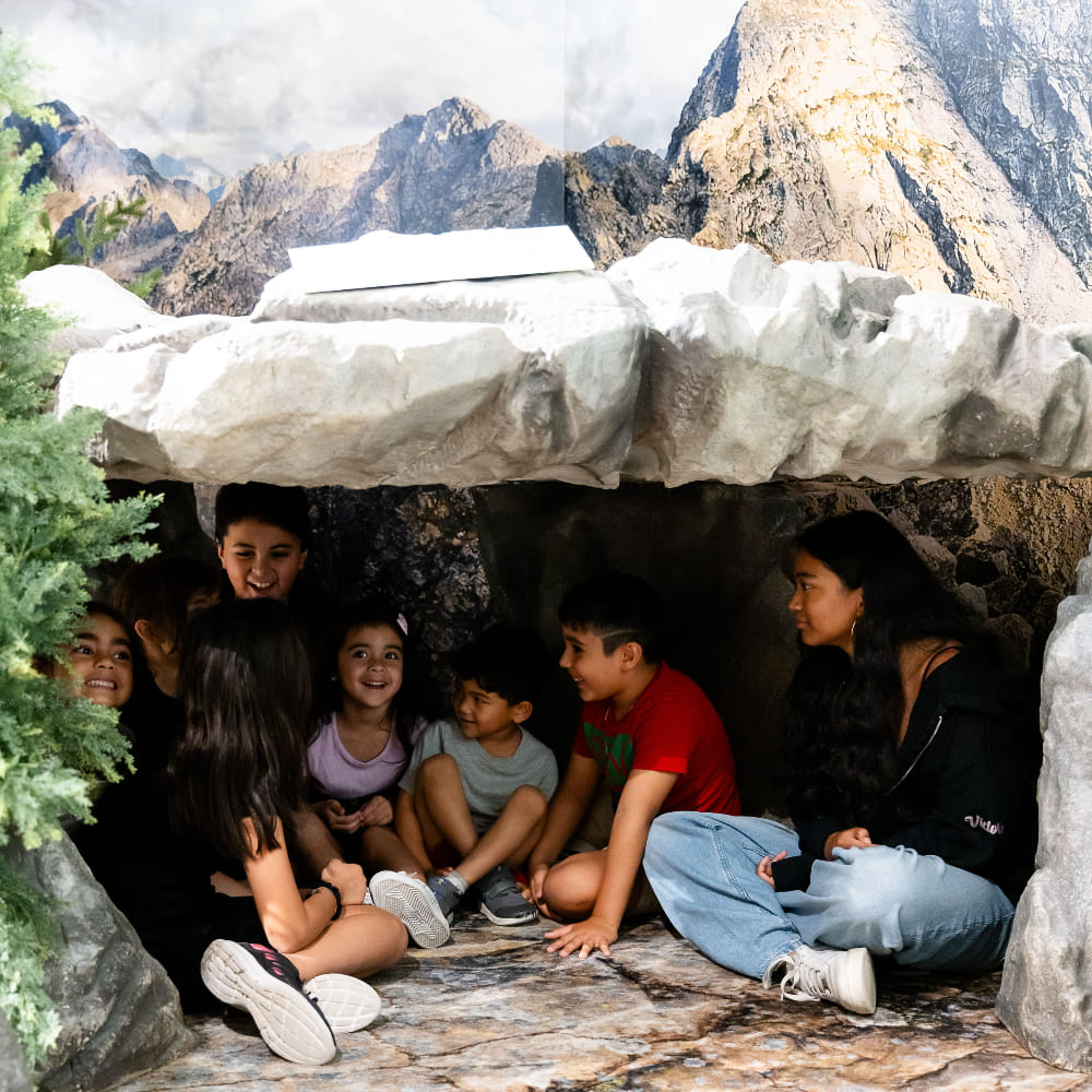 Un groupe d'enfants assis à l'intérieur de la grotte.