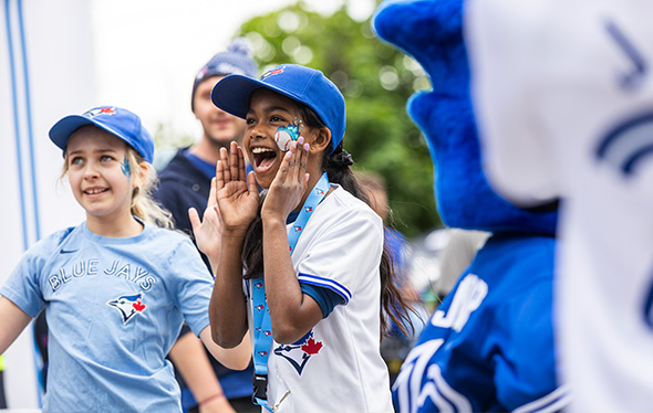 Deux filles portant une casquette et un t-shirt des Blue Jays s'enthousiasment dehors.