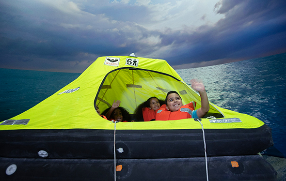 Children are smiling in a lifeboat.