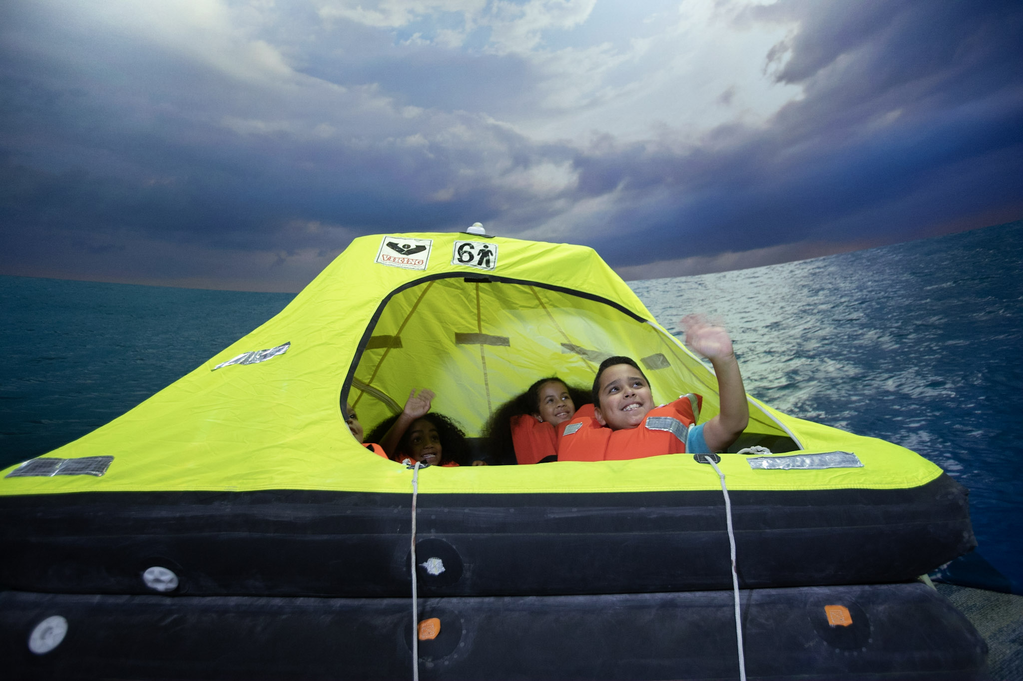 Children are smiling in a lifeboat.